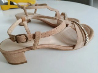 Sandalias elegantes de piel beige y fina pedrería.