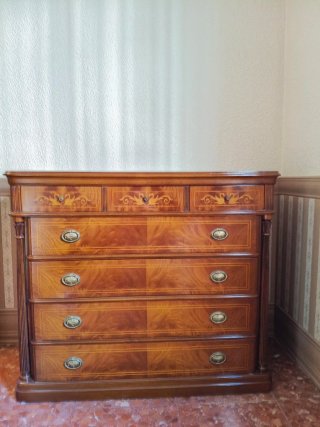 Mueble de entrada de madera con detalles dorados.