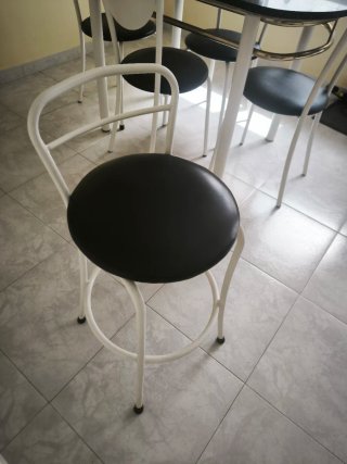 Mesa de cocina con 4 sillas blancas y 1 taburete