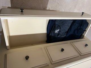 Cómoda de madera beige con cajones.