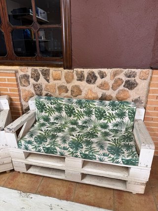 Sofás y mesa de palets con cojines y cristal