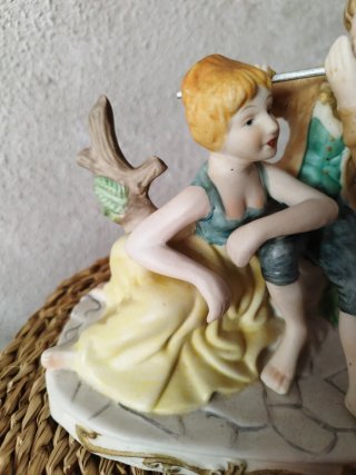 Figura de porcelana de pareja tocando flauta