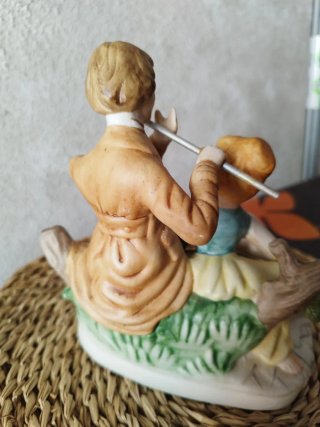 Figura de porcelana de pareja tocando flauta