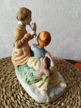 Figura de porcelana de pareja tocando flauta