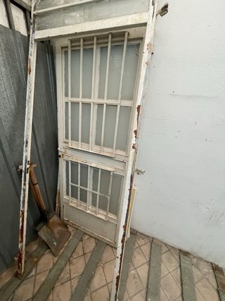 Puerta de hierro con ventanas y rejas