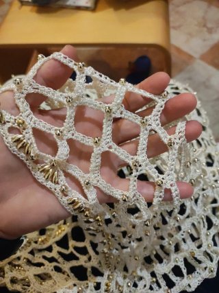 Prenda artesanal de ganchillo con cuentas doradas