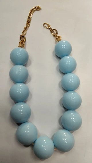 Collana perle azzurre grandi con catena dorata.