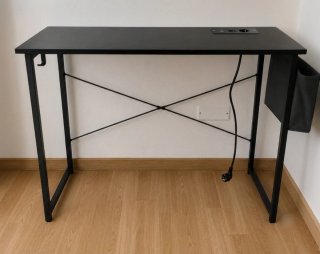 Escritorio negro con enchufes integrados