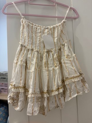 Blusa dorada y blanca con volantes