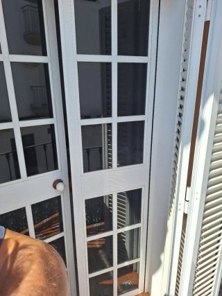 Puerta blanca con cristal y ventanas balconeras