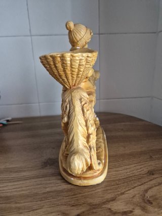 Estatuilla niño montado en perro con cesta