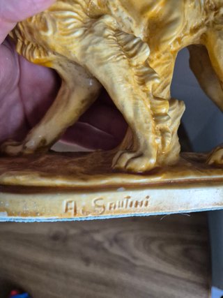 Estatuilla niño montado en perro con cesta