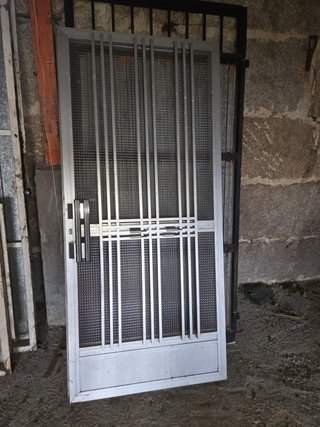 Puerta aluminio gris con cristal y reja
