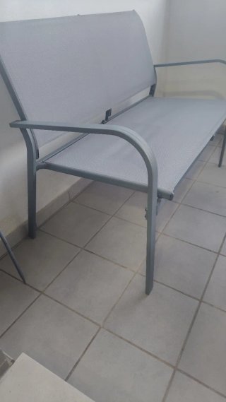 Conjunto de terraza compuesto por sofá y mesa gris
