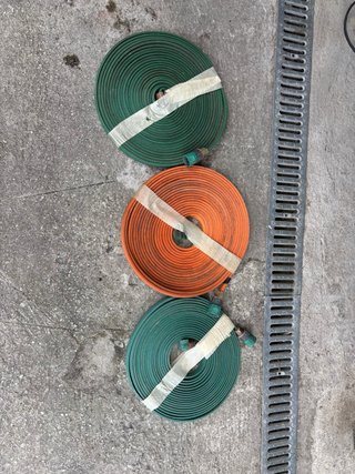 Mangueras de riego enrolladas (2 verdes, 1 naranja