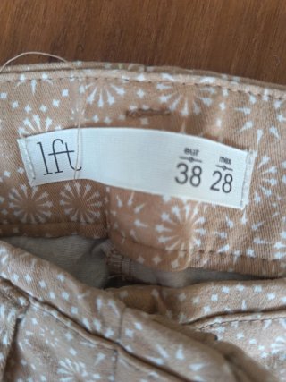Pantalones beige con estampado blanco
