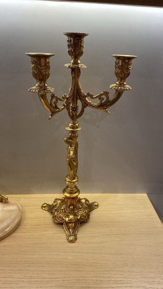 Reloj y candelabros de metal dorados.