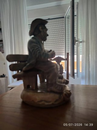 Figura de porcelana hombre sentado banco