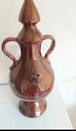 Precioso botijo de cerámica marrón para decoració
