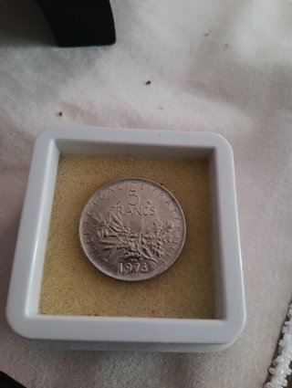 Moneda antigua con figura femenina