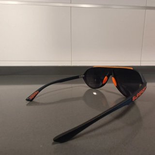 Gafas de sol Superdry negras y naranjas.