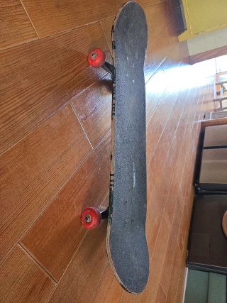 Monopatín negro con ruedas rojas