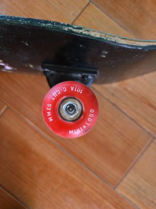 Monopatín negro con ruedas rojas