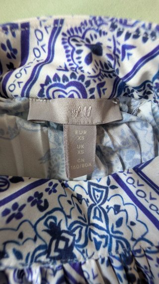 Blusa plisada azul y blanca sin mangas