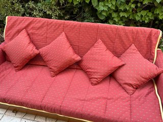 Sofá cama madera y tela rojo.