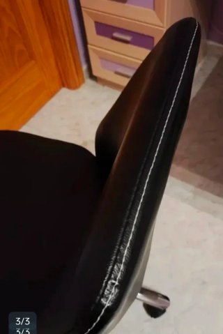 Silla giratoria piel sintética negra con ruedas.