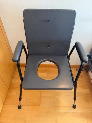 Silla de baño adaptada, con patas extensibles.