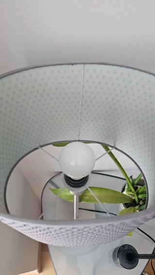 Lámpara de mesa con pantalla gris.