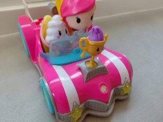 Coche de juguete rosa con figuras