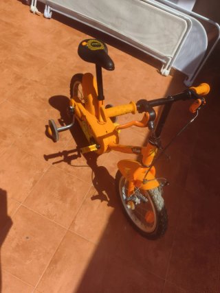 Bicicleta infantil naranja con ruedines