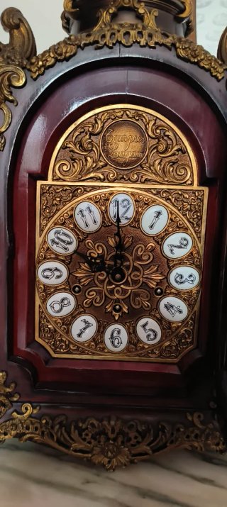 Reloj de sobremesa antiguo y cúpula con santo