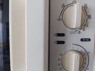Microondas blanco con soporte de pared.