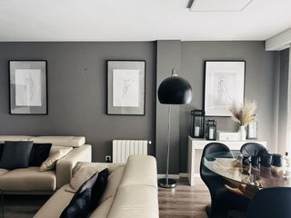 Lámpara de pie cromada curva con tulipa negra.