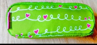 Estuche verde con corazones rosas