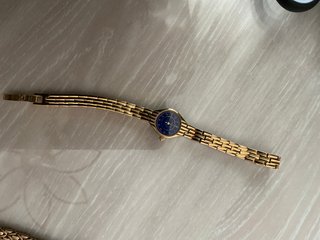 Reloj dorado con esfera azul.