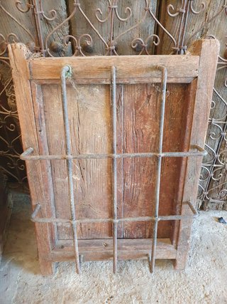 Ventana rústica con reja de madera