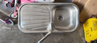 Fregadero de cocina de metal con el grifo.