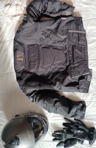 Chaqueta de moto negra y casco.