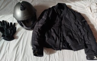 Chaqueta de moto negra y casco.