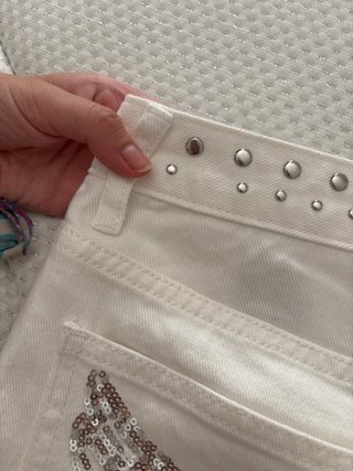Pantalones blancos con alas plateadas y tachulas