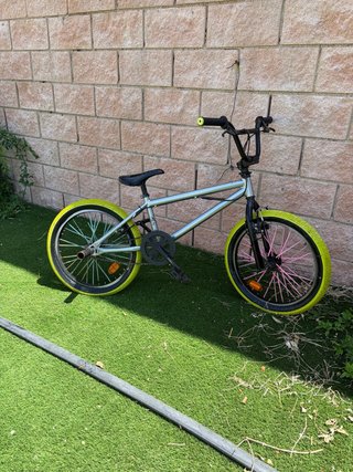 Bicicleta BMX plateada con ruedas amarillas
