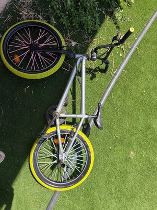 Bicicleta BMX plateada con ruedas amarillas