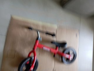 Bicicleta infantil roja sin pedales.