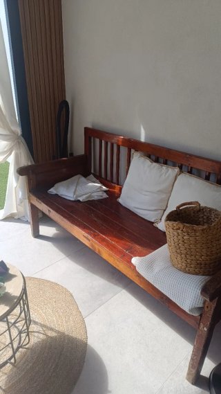 Banco de madera con cojines y cesto