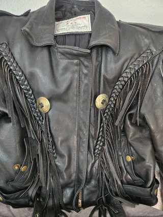Chaqueta de cuero negra con flecos y adornos dorad