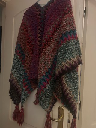 Poncho tejido multicolor con borlas en cada pico